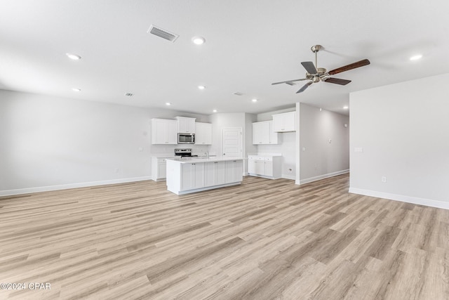 unfurnished living room with recessed lighting, visible vents, light wood-style flooring, a ceiling fan, and baseboards