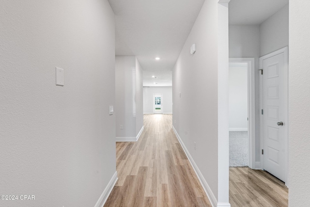 hall with light wood finished floors and baseboards