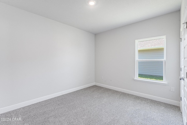 carpeted spare room with baseboards