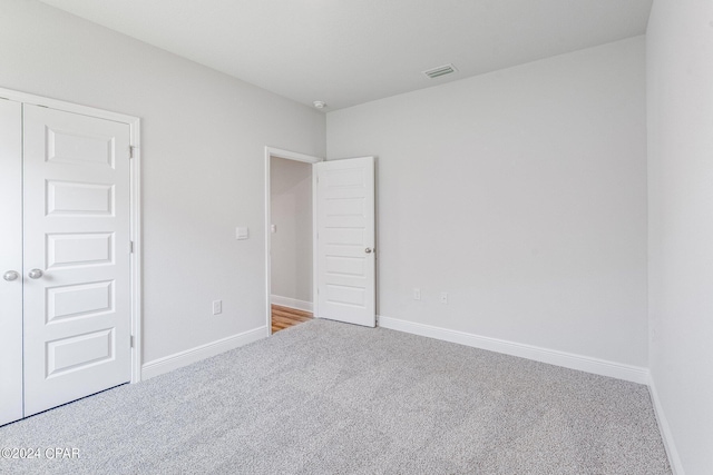 carpeted empty room featuring visible vents and baseboards