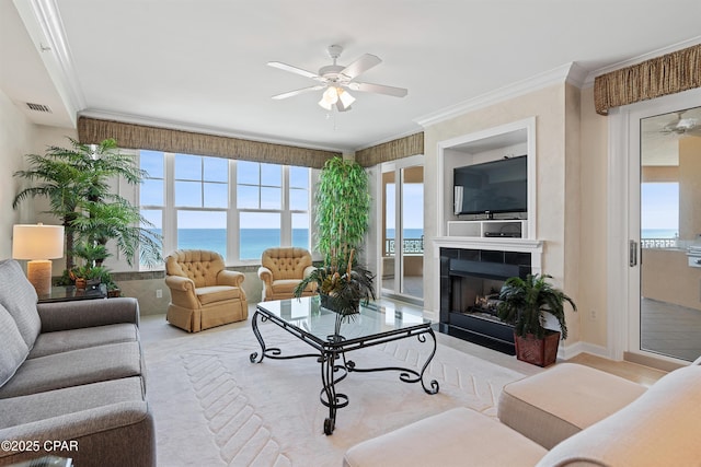 living area with ceiling fan, a fireplace, visible vents, and crown molding