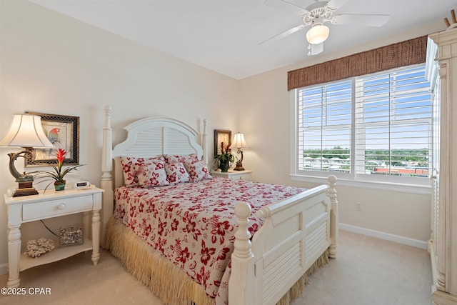 bedroom with light carpet, ceiling fan, and baseboards