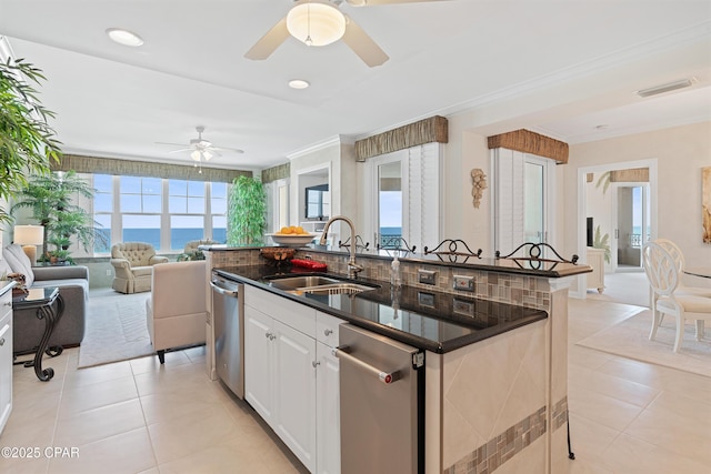 kitchen featuring light tile patterned flooring, a sink, open floor plan, an island with sink, and crown molding