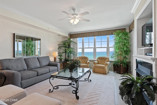 living area with ceiling fan, a fireplace, and crown molding