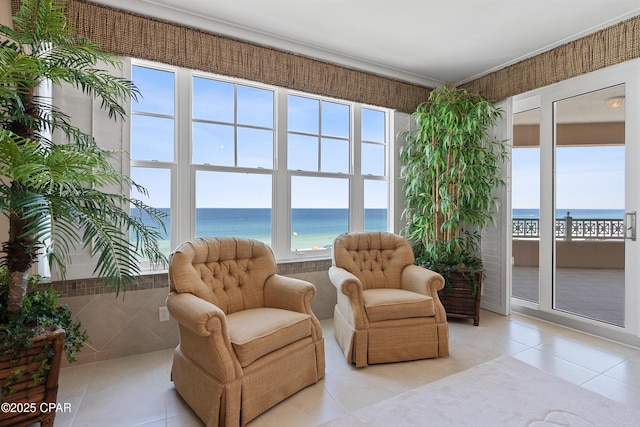 sitting room featuring light tile patterned floors, a water view, and a healthy amount of sunlight