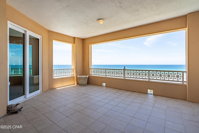 interior space featuring a water view and a textured ceiling