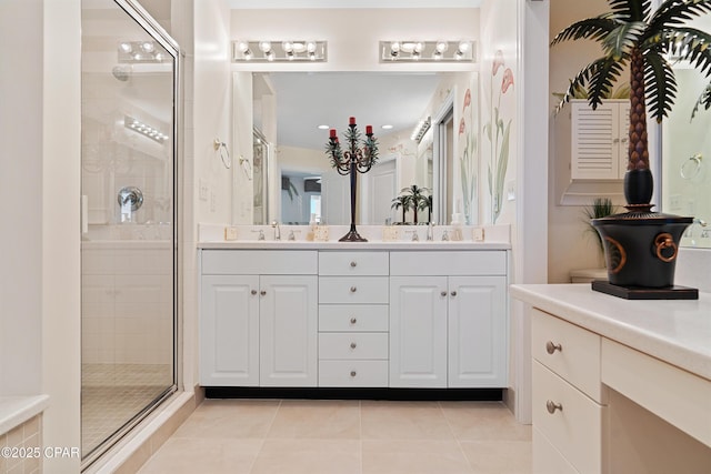 bathroom featuring double vanity, a stall shower, tile patterned flooring, and a sink