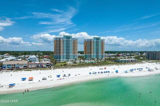 drone / aerial view featuring a water view, a view of city, and a view of the beach