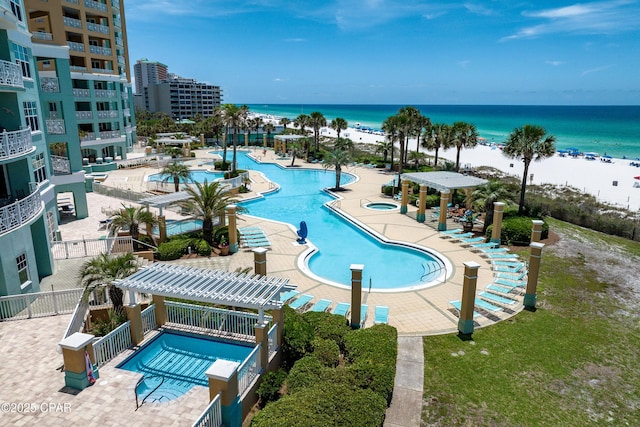 pool featuring a water view, a patio area, a beach view, and a pergola