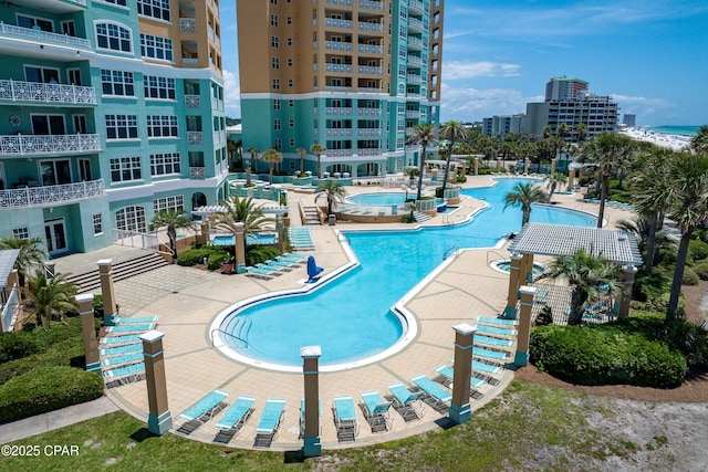 community pool with a patio area and a view of city