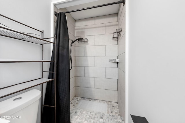 bathroom featuring toilet and a shower stall