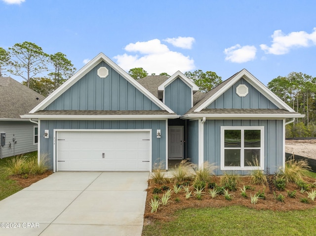 view of front of home with concrete driveway, a shingled roof, board and batten siding, and an attached garage