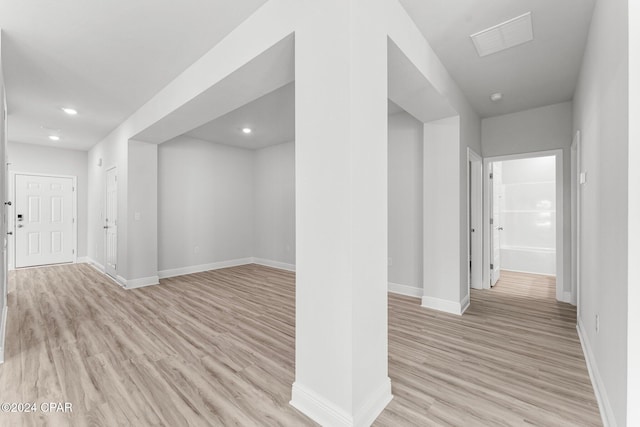 below grade area with light wood finished floors, baseboards, and recessed lighting