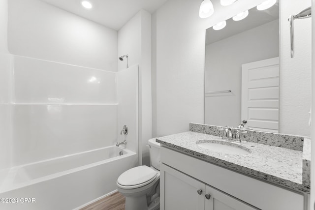 bathroom with wood finished floors, shower / bath combination, vanity, and toilet