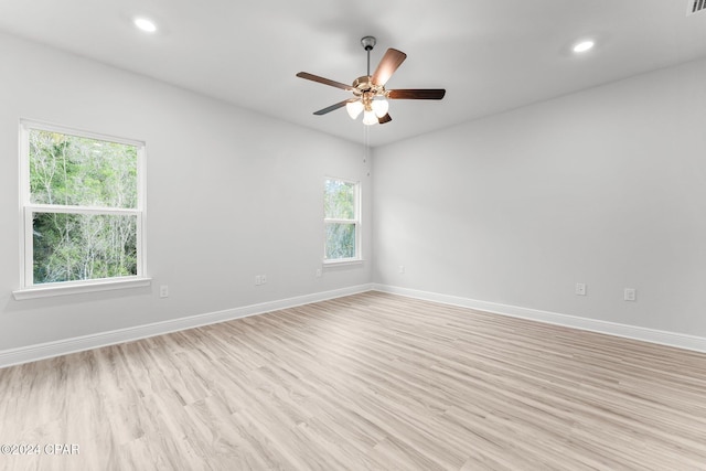 empty room featuring light wood-style floors, baseboards, and recessed lighting