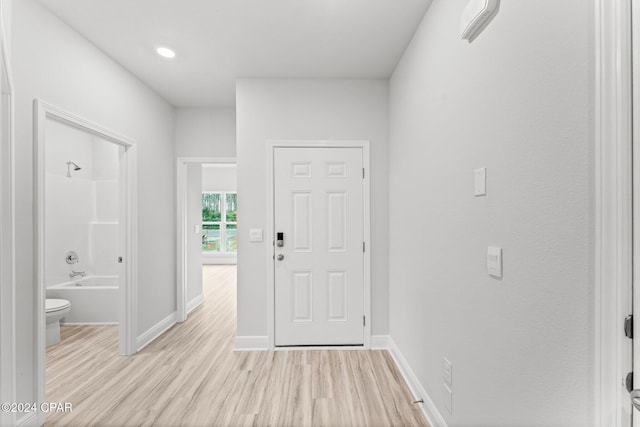 foyer entrance featuring light wood-style floors and baseboards