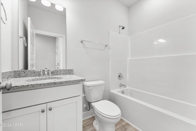 full bath with shower / washtub combination, toilet, vanity, wood finished floors, and baseboards