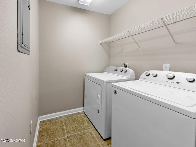 laundry area with light tile patterned floors, washing machine and dryer, laundry area, electric panel, and baseboards