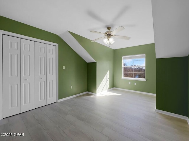 additional living space with ceiling fan, vaulted ceiling, wood finished floors, and baseboards