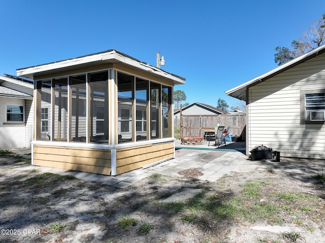 view of home's exterior featuring a patio area, fence, and a sunroom