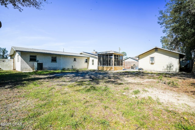 back of house with a lawn, cooling unit, a sunroom, and fence