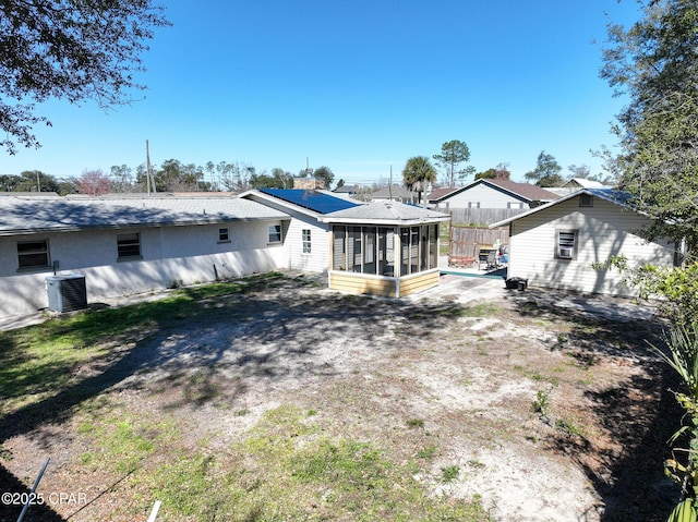 rear view of property with a sunroom, fence, and central air condition unit