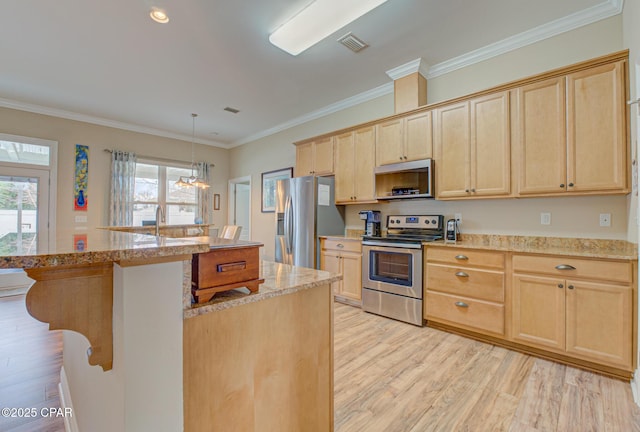 kitchen with light wood-style floors, a kitchen island, pendant lighting, and stainless steel appliances