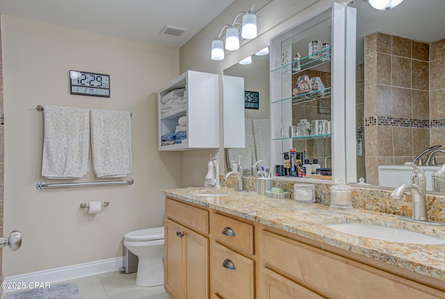 full bathroom featuring toilet, tile patterned flooring, double vanity, and a sink