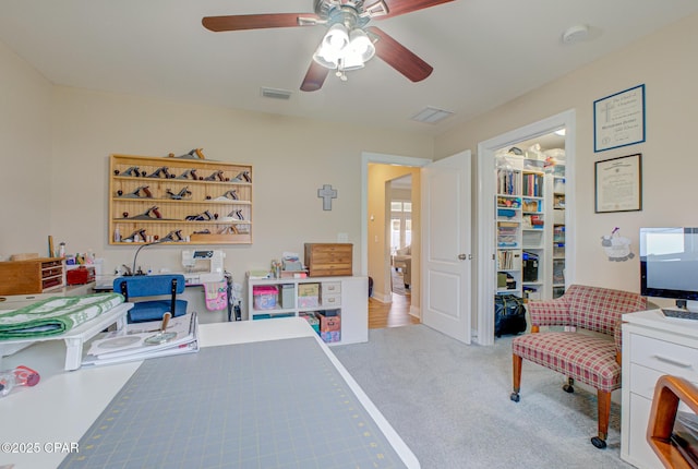 interior space featuring visible vents, a ceiling fan, light colored carpet, a spacious closet, and a closet