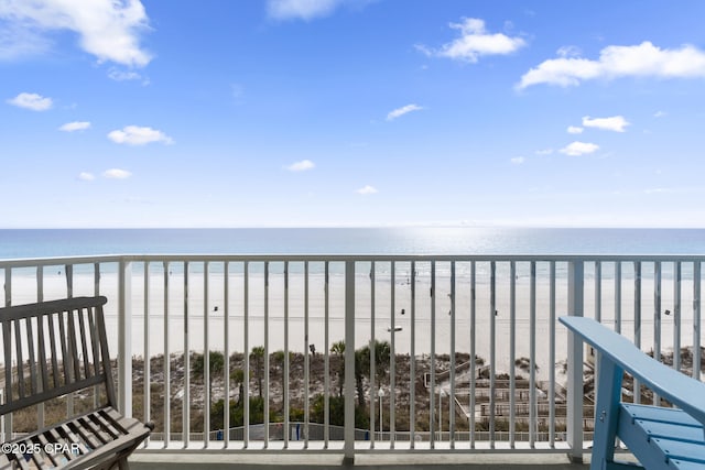 balcony featuring a water view and a beach view