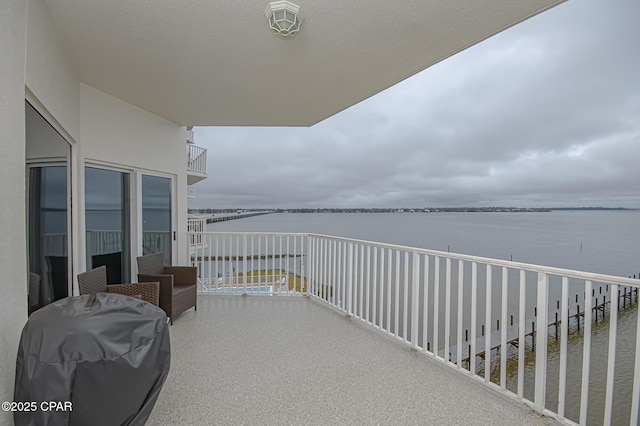 balcony with a water view and area for grilling