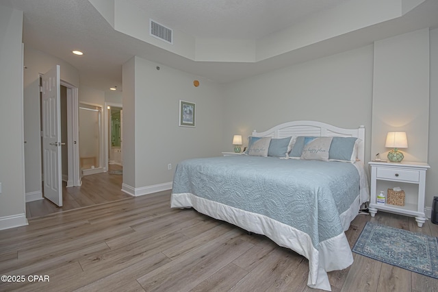 bedroom with a textured ceiling, recessed lighting, visible vents, baseboards, and light wood-type flooring