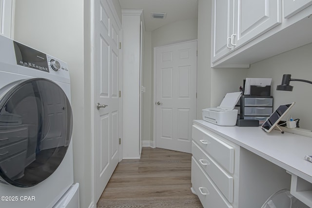 clothes washing area featuring visible vents, light wood-style flooring, cabinet space, and washer / dryer