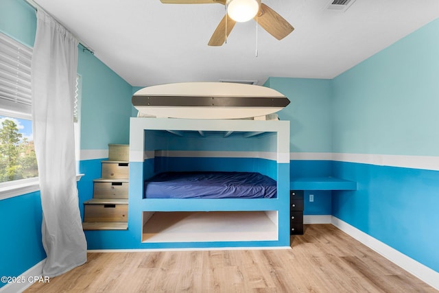 unfurnished bedroom featuring wood finished floors, a ceiling fan, and baseboards