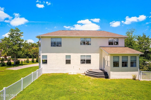 back of property featuring a yard, a fenced backyard, and stucco siding