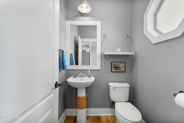 bathroom featuring baseboards, toilet, and wood finished floors