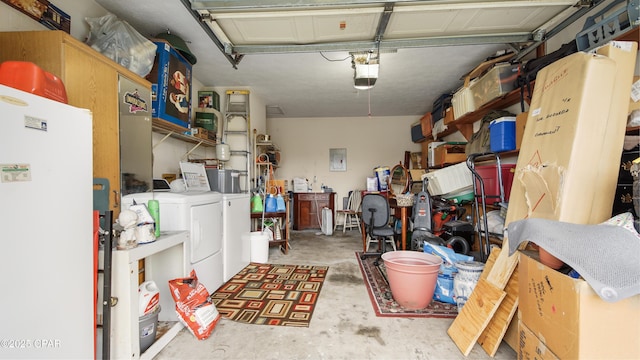 garage featuring a garage door opener, washing machine and dryer, and freestanding refrigerator