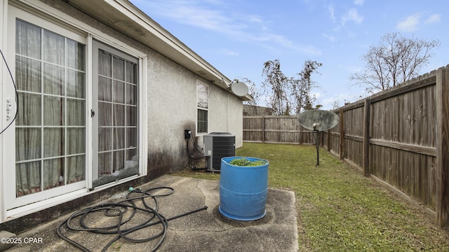 view of yard with a patio area, a fenced backyard, and central AC unit