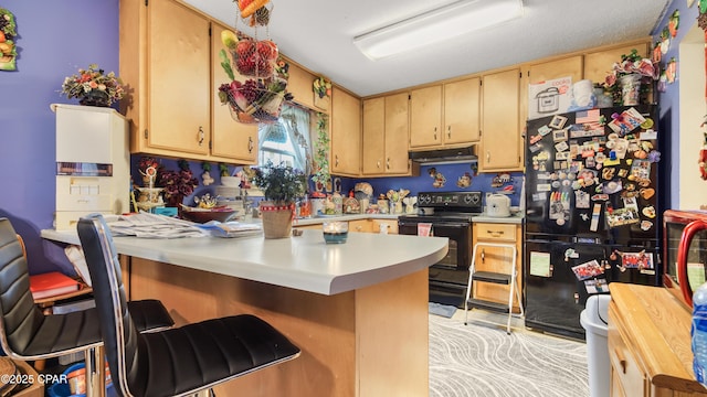 kitchen with a breakfast bar area, a peninsula, under cabinet range hood, light countertops, and black appliances