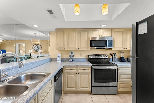 kitchen featuring stainless steel appliances, light countertops, hanging light fixtures, visible vents, and a sink