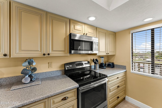 kitchen with light countertops, appliances with stainless steel finishes, recessed lighting, and baseboards