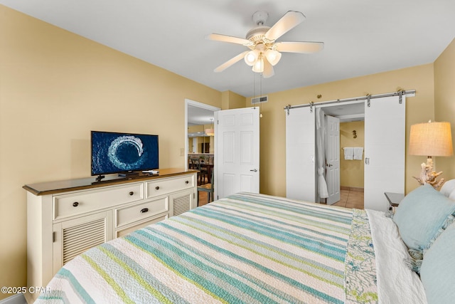 bedroom with light tile patterned flooring, visible vents, ceiling fan, and a barn door