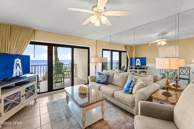 living area with a ceiling fan and light tile patterned flooring