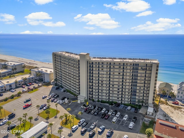 birds eye view of property with a water view and a beach view