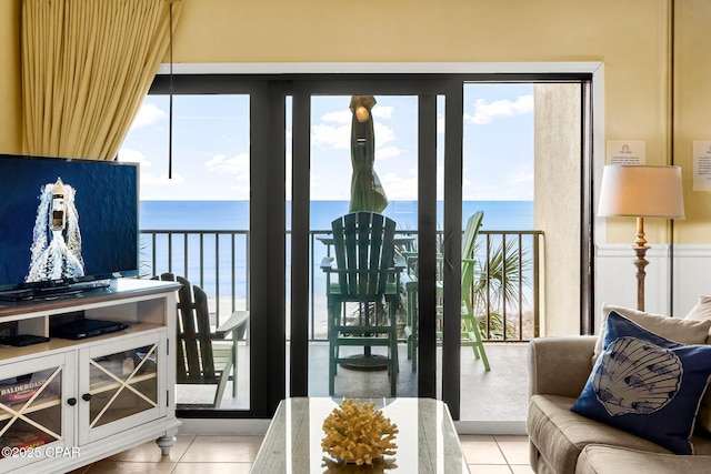 doorway with a water view, plenty of natural light, and light tile patterned floors