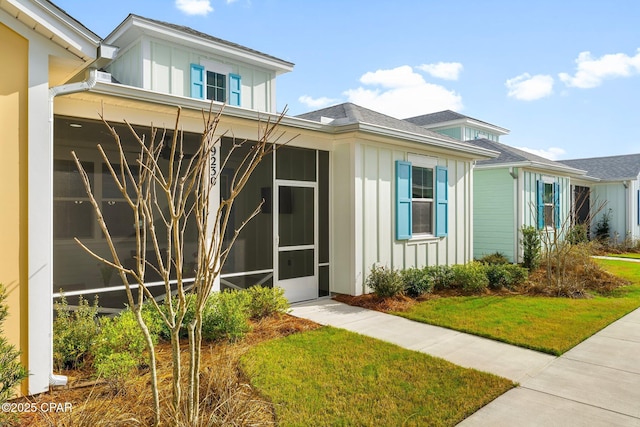 property entrance featuring board and batten siding and a yard