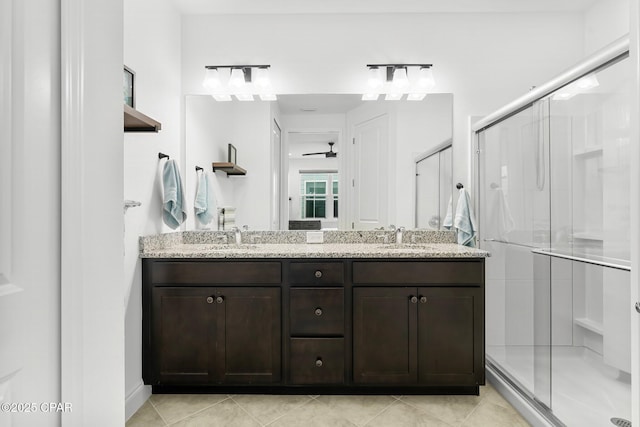 full bath with double vanity, ceiling fan, a shower stall, and a sink