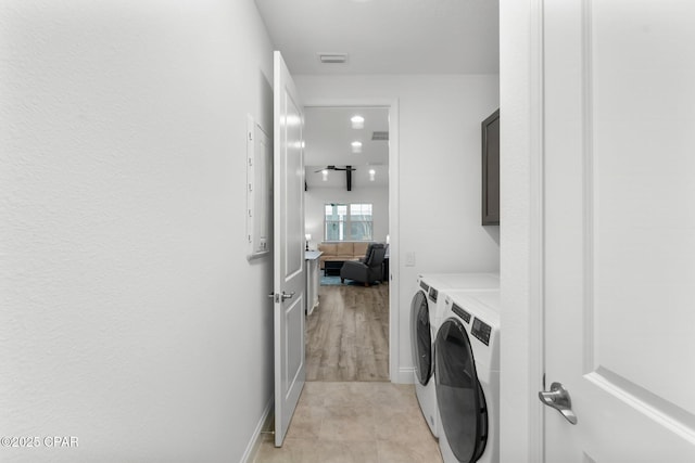 laundry room featuring separate washer and dryer, cabinet space, baseboards, and visible vents