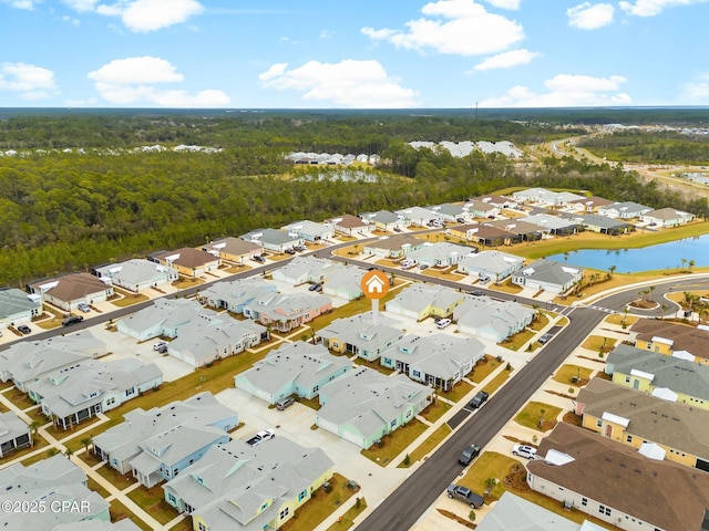 bird's eye view featuring a water view, a view of trees, and a residential view