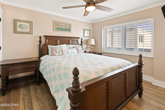 bedroom with dark wood-style floors, ornamental molding, a ceiling fan, and baseboards